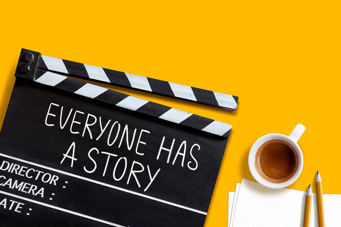 Everyone has a story.world title on film slate and coffee cup on yellow background